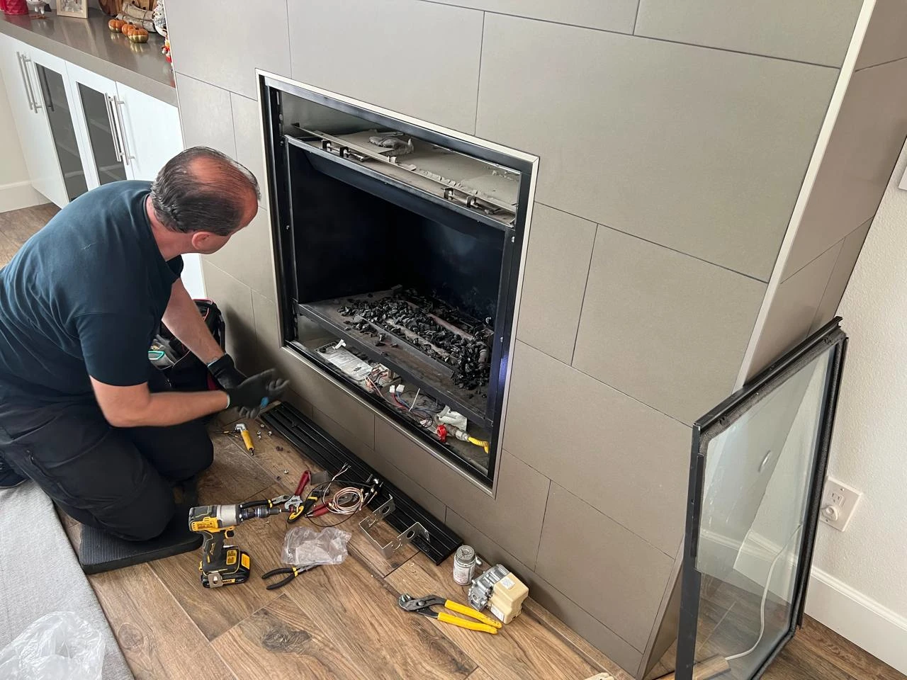 A plumber is fixing the fireplace
